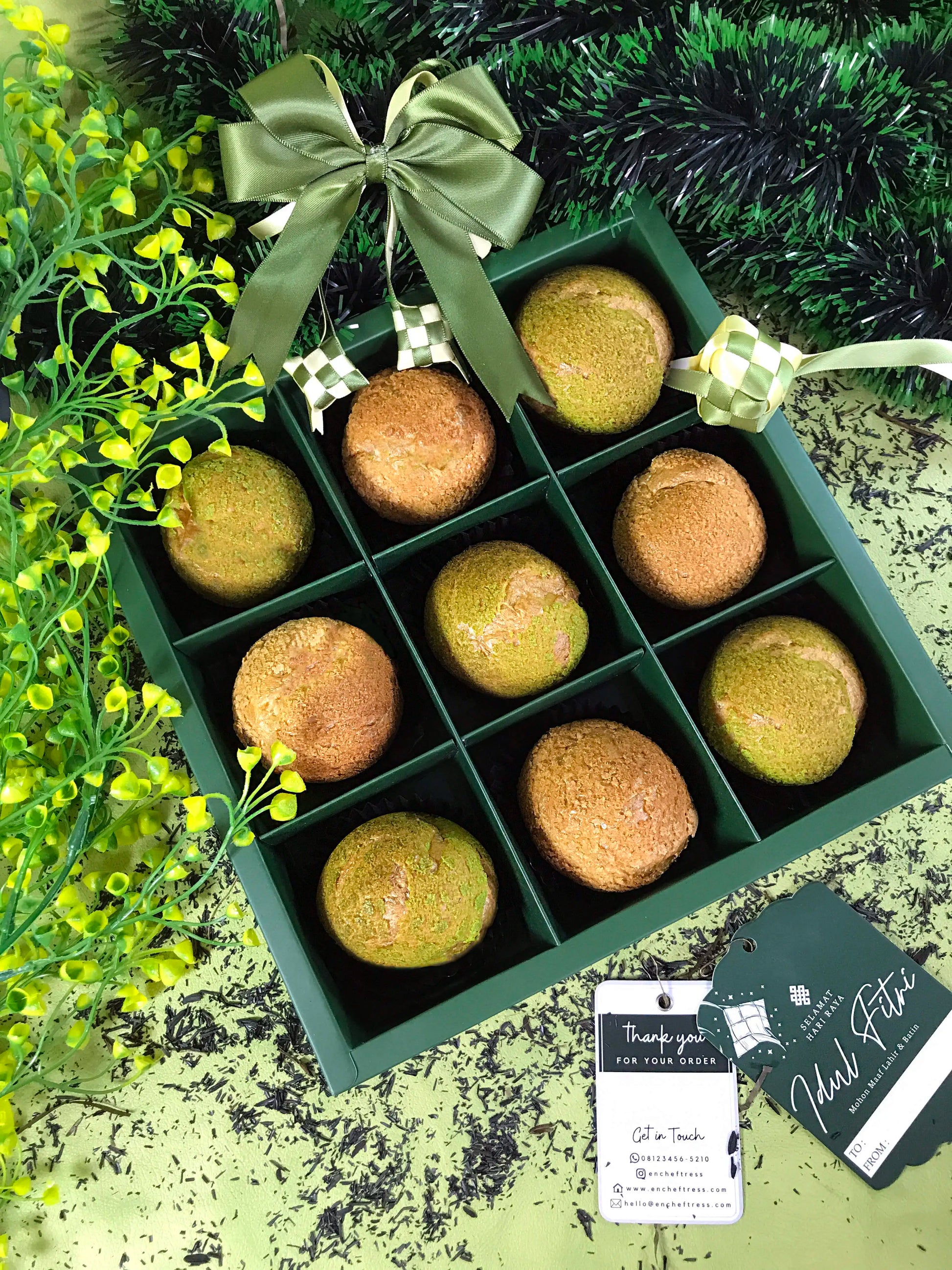 A green box containing nine choux au craquelin pastries, decorated with a green ribbon and a 'Selamat Hari Raya Idul Fitri' tag, reflecting a Ramadan theme.